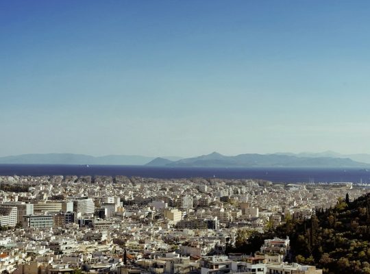 a city with a body of water in the background