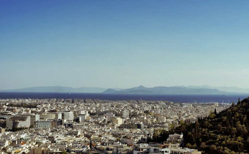 a city with a body of water in the background